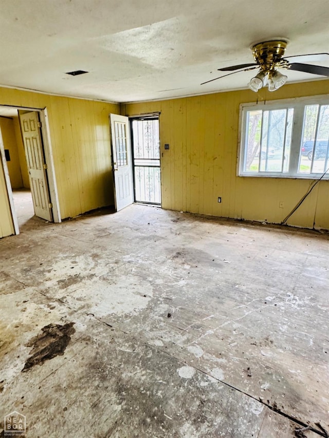 315 Arrington St, Newport, AR 72112 - empty room with ceiling fan and wood walls