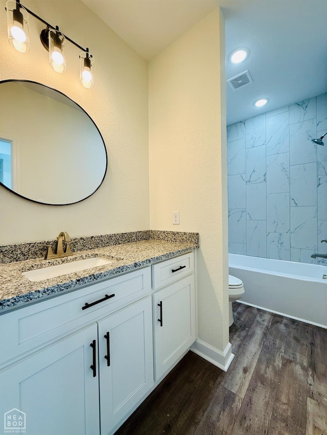 bathroom featuring vanity, recessed lighting, toilet, shower / bath combination, and wood finished floors