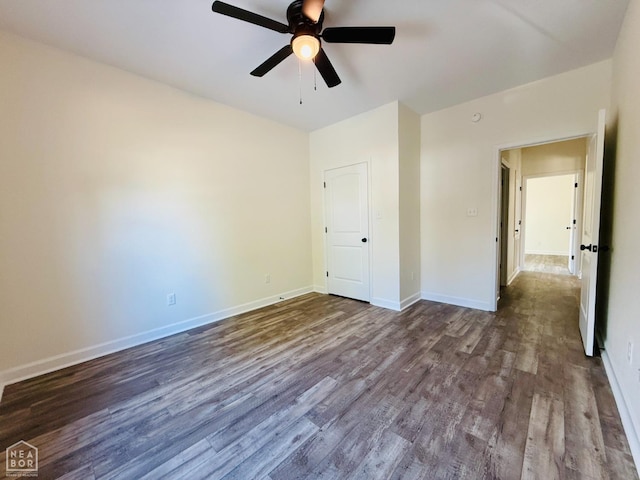 unfurnished bedroom featuring ceiling fan, dark wood-style flooring, and baseboards