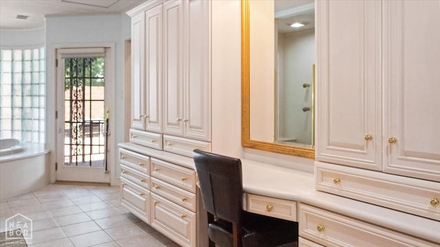 home office with built in desk and light tile patterned flooring