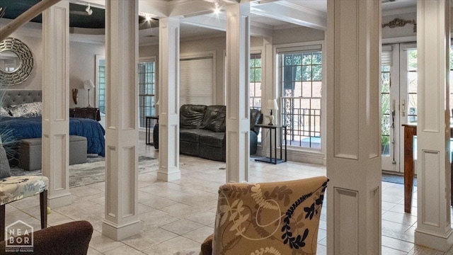 doorway to outside with light tile patterned floors, ornate columns, and crown molding