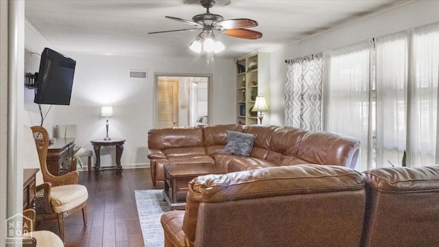 living area featuring visible vents, a ceiling fan, ornamental molding, and dark wood finished floors