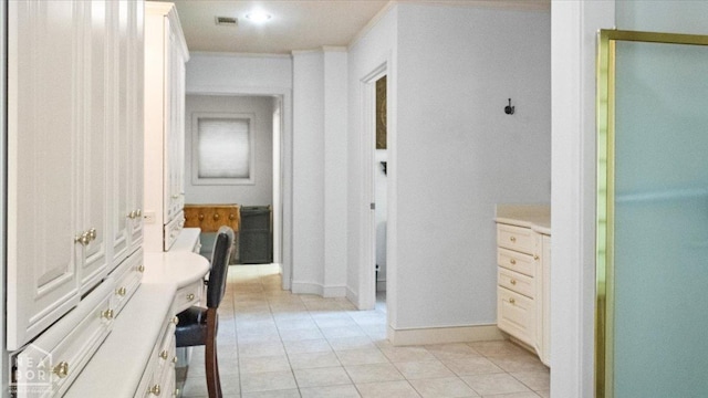 hall with light tile patterned floors, baseboards, and visible vents