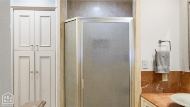 bathroom with a shower stall and a sink