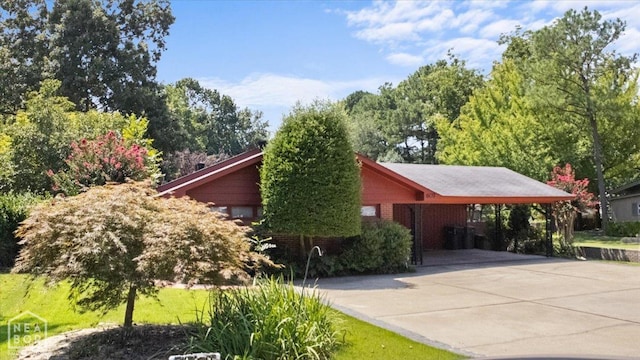 view of side of property featuring a carport and driveway