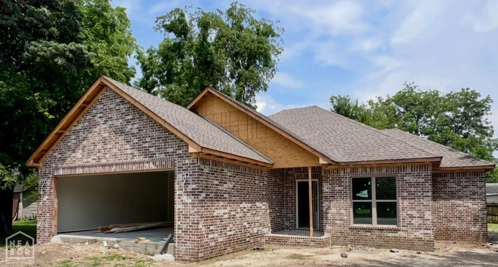 408 S Baltimore Ave, Manila, AR 72442 - view of front of house with brick siding, a garage, and roof with shingles