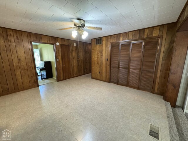 937 Homecrest Dr, Piggott, AR 72454 - unfurnished bedroom with wooden walls, ceiling fan, and light flooring