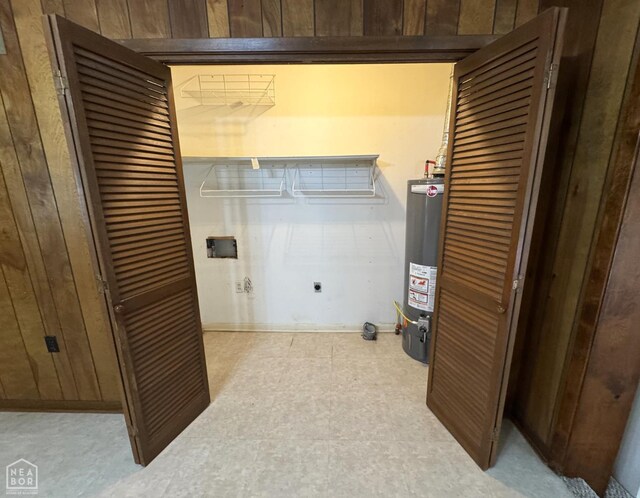 937 Homecrest Dr, Piggott, AR 72454 - washroom with water heater, electric dryer hookup, light flooring, and wood walls