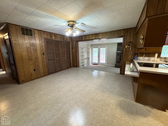 937 Homecrest Dr, Piggott, AR 72454 - kitchen with wooden walls, ceiling fan, french doors, light floors, and light countertops