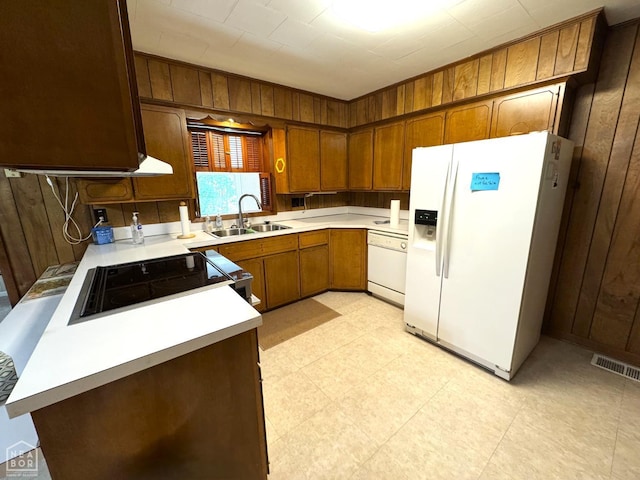937 Homecrest Dr, Piggott, AR 72454 - kitchen featuring white appliances, wood walls, light countertops, and brown cabinets