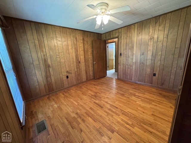 937 Homecrest Dr, Piggott, AR 72454 - empty room with wood finished floors, a ceiling fan, and wood walls
