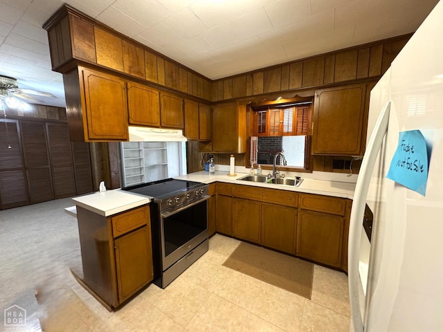 937 Homecrest Dr, Piggott, AR 72454 - kitchen with stainless steel electric stove, freestanding refrigerator, under cabinet range hood, wood walls, and light countertops