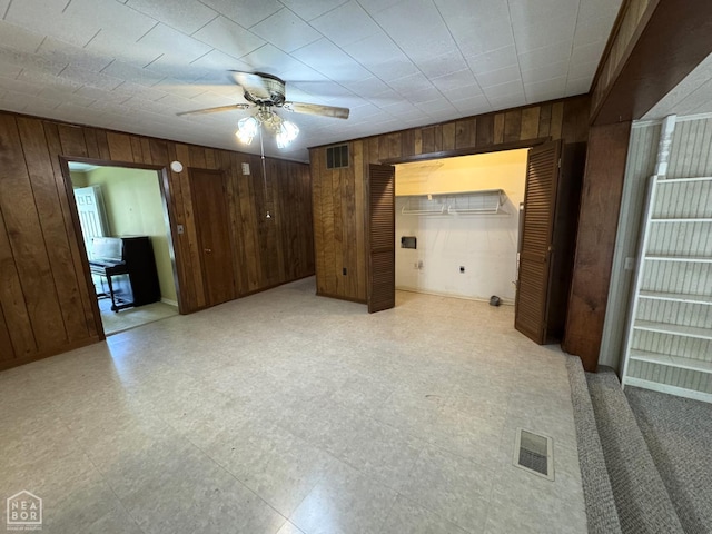 937 Homecrest Dr, Piggott, AR 72454 - unfurnished bedroom featuring wood walls, light flooring, multiple closets, and ceiling fan
