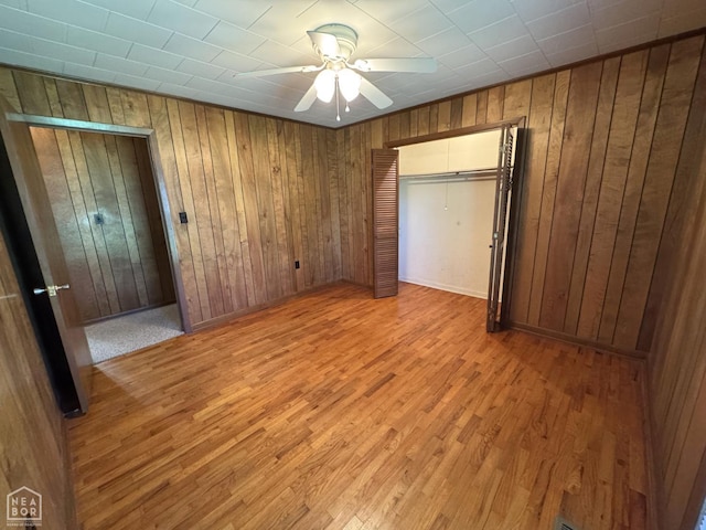 937 Homecrest Dr, Piggott, AR 72454 - unfurnished bedroom featuring wood walls, light wood-type flooring, and a ceiling fan