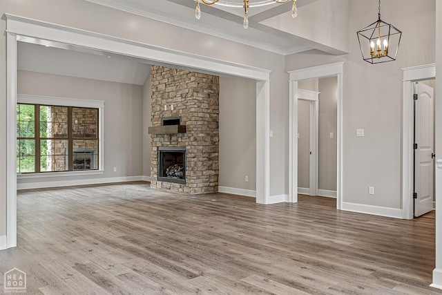 unfurnished living room featuring a chandelier, baseboards, and wood finished floors