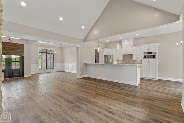 kitchen featuring a chandelier, premium range hood, appliances with stainless steel finishes, and white cabinets