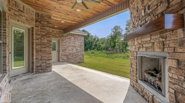 view of patio featuring an outdoor stone fireplace and ceiling fan