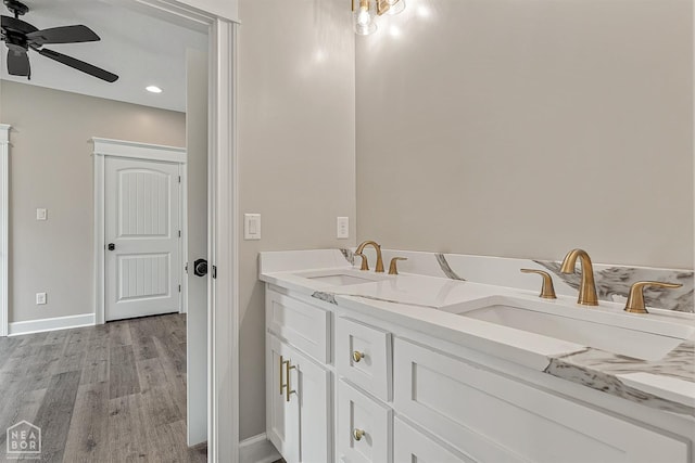 bathroom with wood finished floors, baseboards, a sink, and ceiling fan