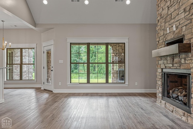 unfurnished living room featuring a fireplace, wood finished floors, and a healthy amount of sunlight