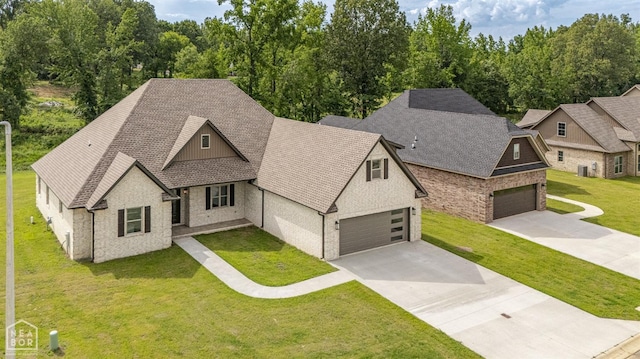 view of front facade featuring concrete driveway, a front yard, and a shingled roof
