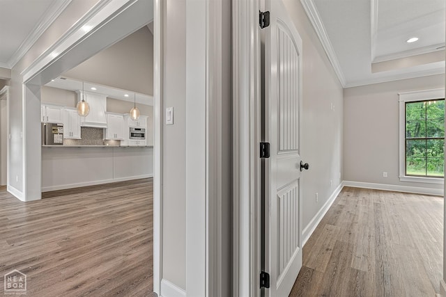 hall with crown molding, baseboards, light wood-type flooring, and recessed lighting