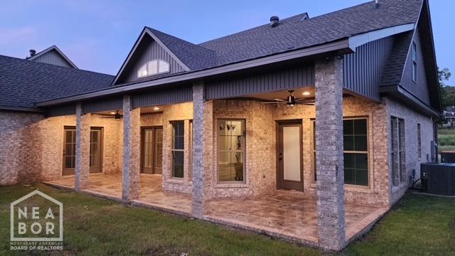 rear view of property featuring a patio area, roof with shingles, and ceiling fan
