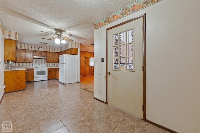 319 Stephans Ln, Corning, AR 72422 - kitchen featuring white appliances, brown cabinetry, light countertops, a textured ceiling, and a ceiling fan