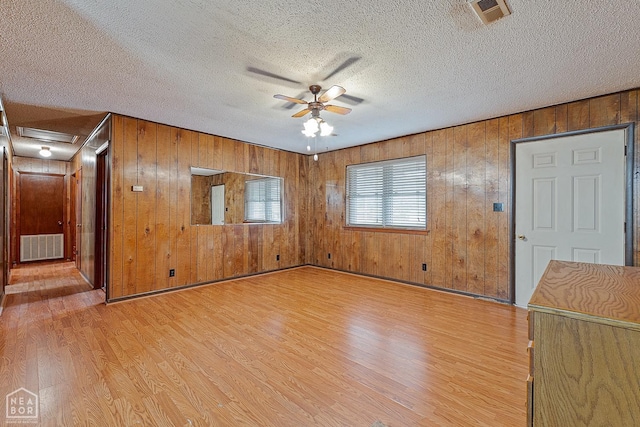 319 Stephans Ln, Corning, AR 72422 - unfurnished room with light wood-style floors, a ceiling fan, wood walls, and a textured ceiling