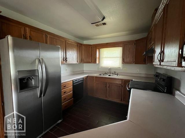 1213 Pauline St, Trumann, AR 72472 - kitchen featuring black appliances, brown cabinetry, under cabinet range hood, and light countertops