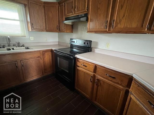 1213 Pauline St, Trumann, AR 72472 - kitchen with black electric range, under cabinet range hood, light countertops, and dark wood-style floors