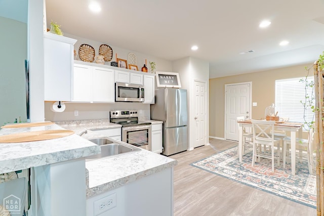 5405 Yukon Dr, Jonesboro, AR 72405 - kitchen featuring appliances with stainless steel finishes, light wood-type flooring, recessed lighting, and white cabinets