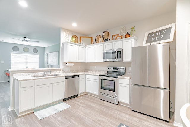5405 Yukon Dr, Jonesboro, AR 72405 - kitchen with stainless steel appliances, white cabinetry, light wood-style floors, a peninsula, and recessed lighting