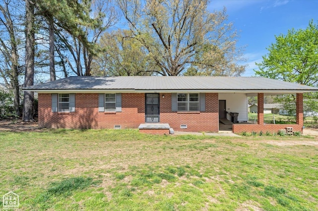 single story home featuring an attached carport, metal roof, and a front yard