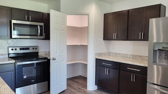 4909 Prospector Dr, Jonesboro, AR 72405 - kitchen with appliances with stainless steel finishes, light countertops, tasteful backsplash, dark wood finished floors, and dark brown cabinetry