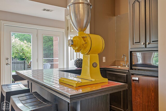 15 Plantation Oaks Ln, Jonesboro, AR 72401 - kitchen with tile counters, a sink, and a breakfast bar