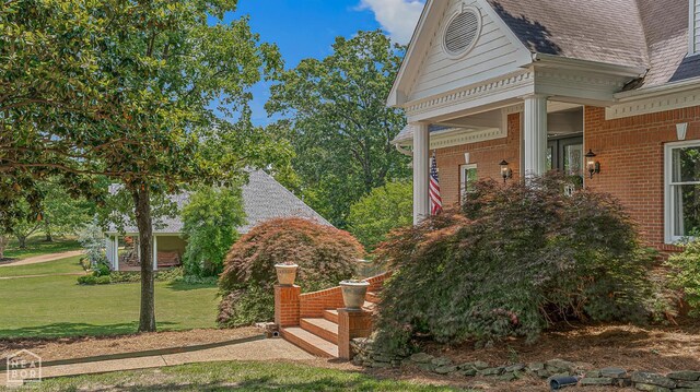 15 Plantation Oaks Ln, Jonesboro, AR 72401 - doorway to property featuring a lawn, brick siding, and roof with shingles