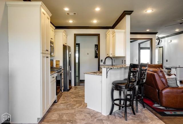 109 Harper Dr, Brookland, AR 72417 - kitchen featuring open floor plan, crown molding, a breakfast bar area, stainless steel appliances, and light stone countertops