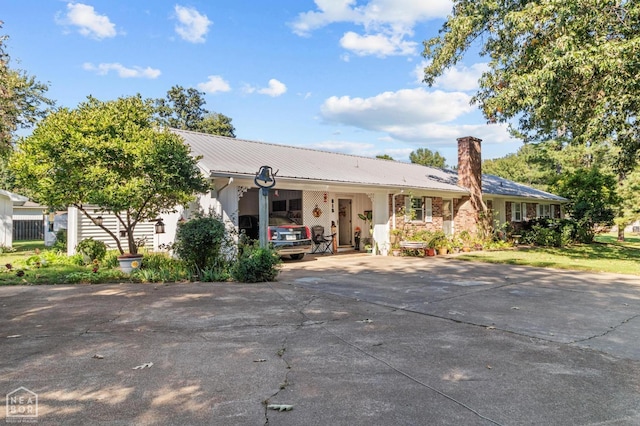 815 NW 3rd St, Walnut Ridge, AR 72476 - ranch-style house with an attached carport, metal roof, a chimney, and concrete driveway