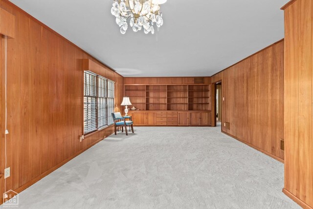 815 NW 3rd St, Walnut Ridge, AR 72476 - unfurnished room featuring built in features, wood walls, a notable chandelier, and carpet floors