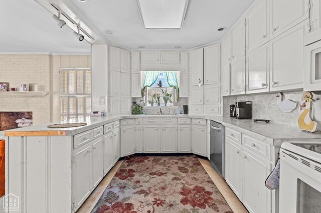 815 NW 3rd St, Walnut Ridge, AR 72476 - kitchen with a peninsula, light countertops, backsplash, white cabinets, and stainless steel dishwasher