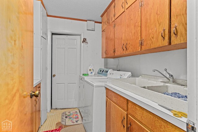 815 NW 3rd St, Walnut Ridge, AR 72476 - washroom with washer and dryer, a sink, a textured ceiling, cabinet space, and light floors