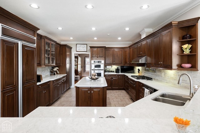 kitchen with open shelves, a kitchen island, under cabinet range hood, double oven, and a sink