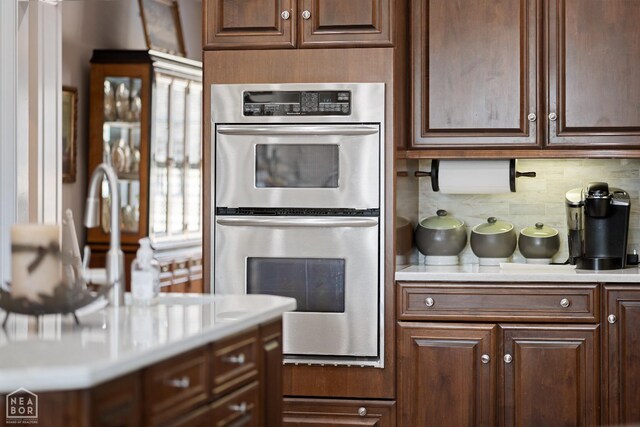295 County Road 118, Bono, AR 72416 - kitchen featuring stainless steel double oven, tasteful backsplash, light countertops, and dark brown cabinets