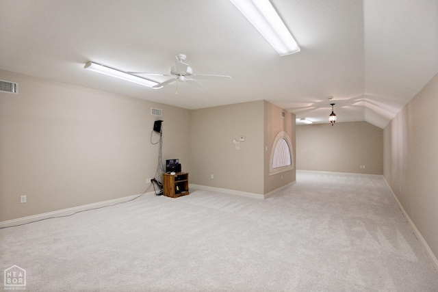interior space featuring visible vents, ceiling fan, light colored carpet, and vaulted ceiling