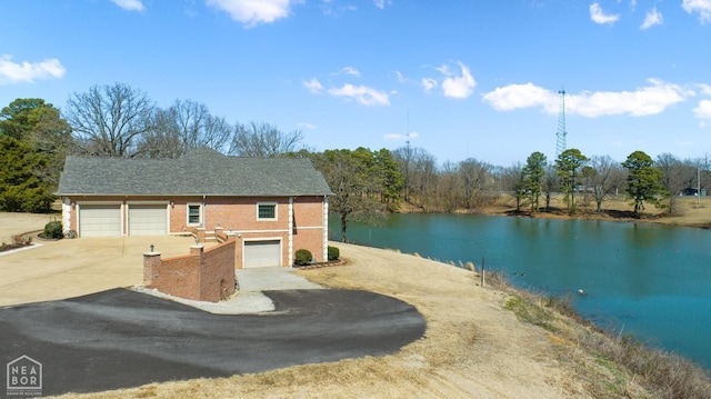 exterior space featuring a water view and concrete driveway