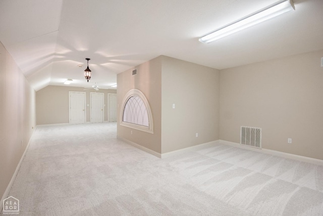 additional living space with light carpet, baseboards, and visible vents