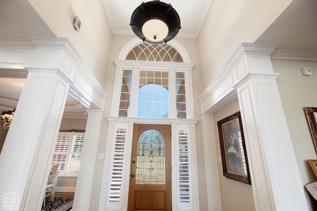 foyer entrance featuring decorative columns and ornamental molding