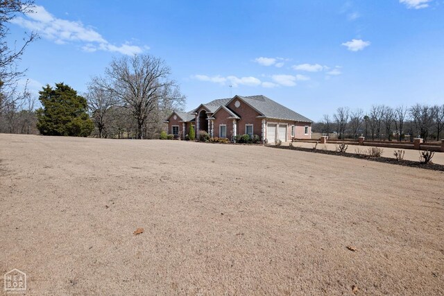 295 County Road 118, Bono, AR 72416 - view of front facade with an attached garage and brick siding