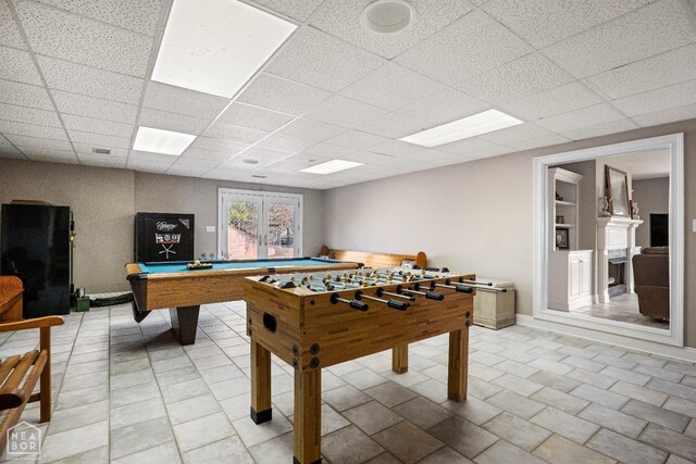 rec room with billiards, a drop ceiling, and baseboards
