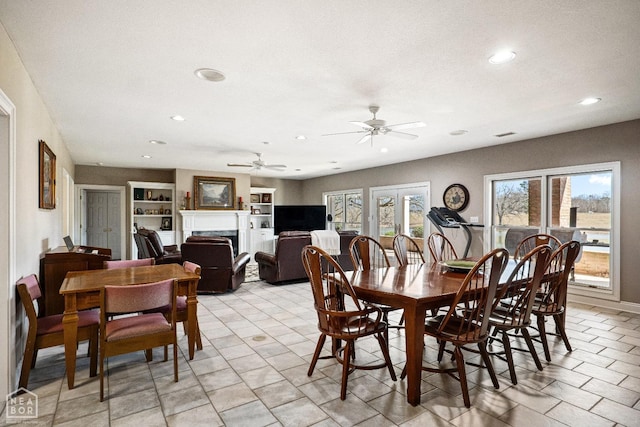 dining room featuring recessed lighting, a fireplace, a ceiling fan, and a wealth of natural light